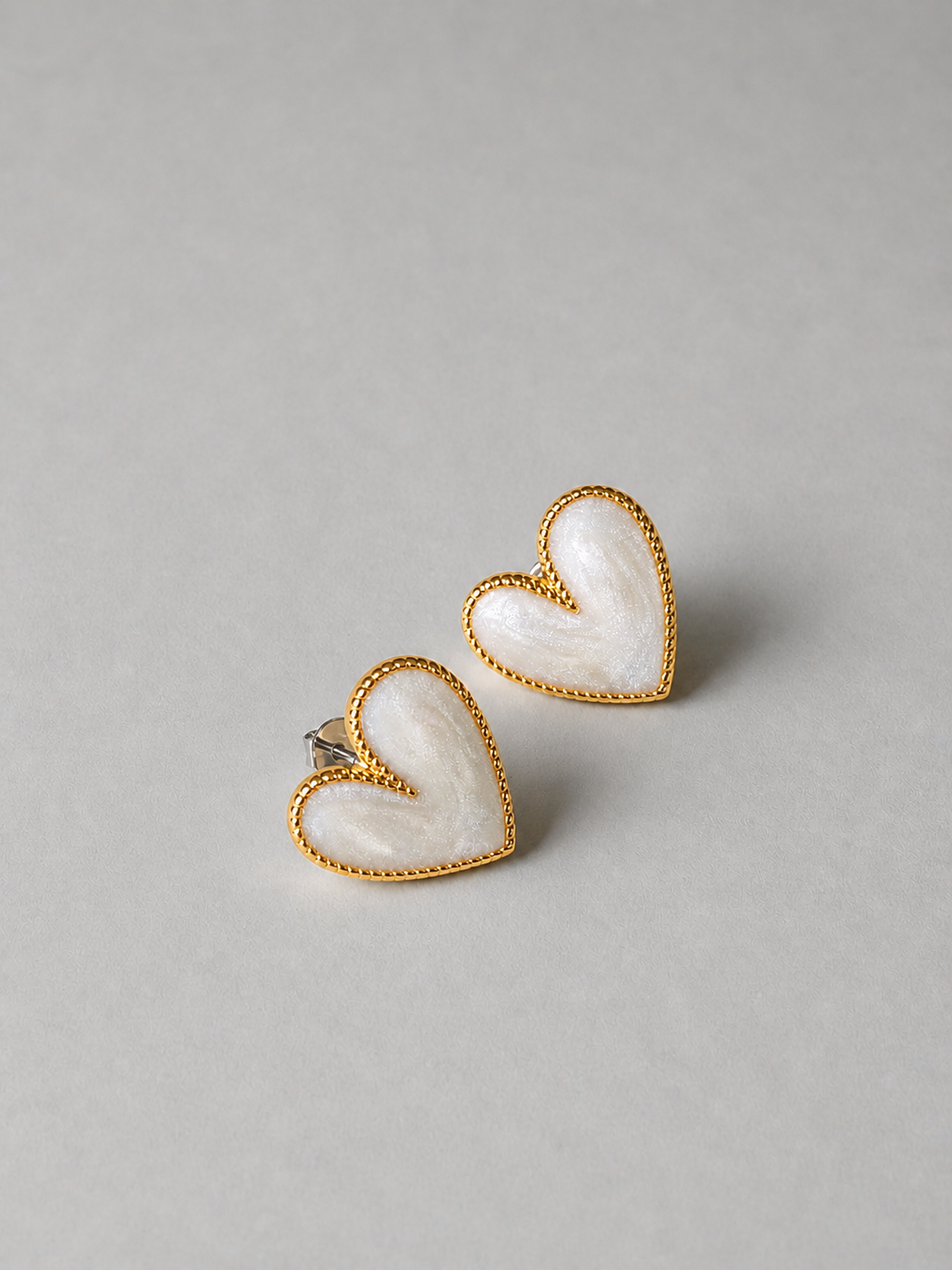 艶のあるハートモチーフが耳元を彩るOUIのAmour Palette Pierce P022のカラーホワイトです。マーブルカラーなので艶感アップ。