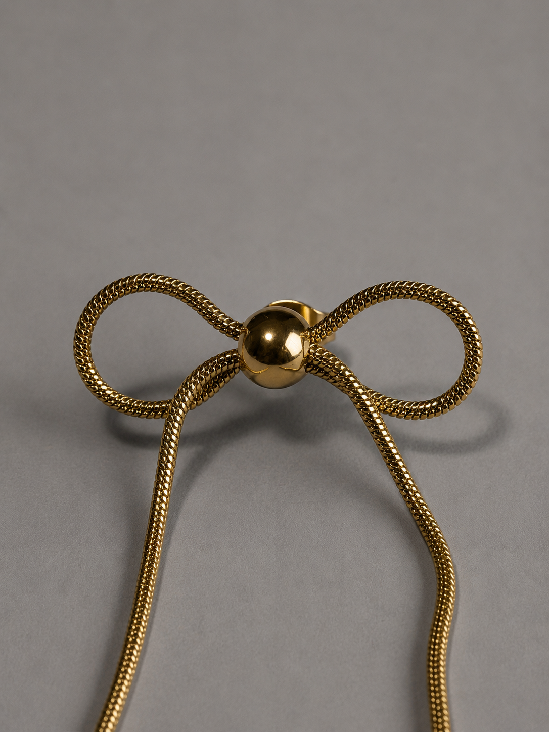 Nouer Pierce P023 リボンピアス P023  金属アレルギー対応ステンレス製のスネークチェーンの蝶々結びリボンの真ん中部分の拡大画像　蝶々結びの結び目の部分は丸型になっている