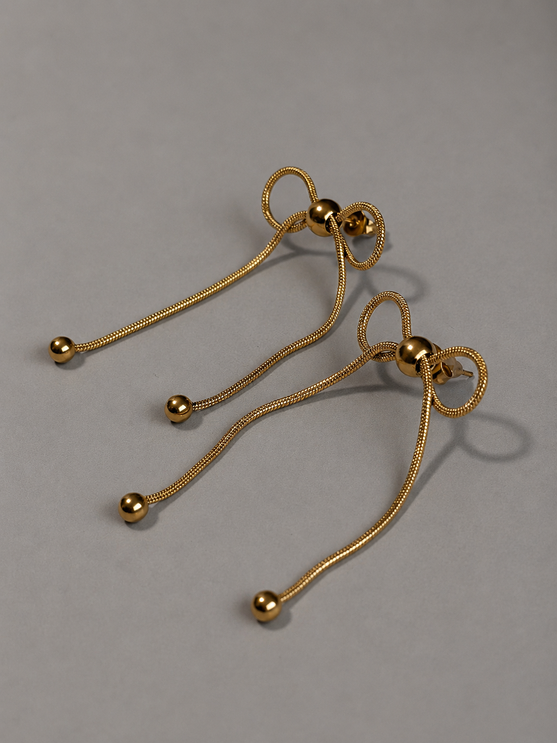 Nouer Pierce P023 リボンピアス P023  金属アレルギー対応ステンレス製のピアスがスネークチェーンのリボン型ピアスがセットで並んでいる
