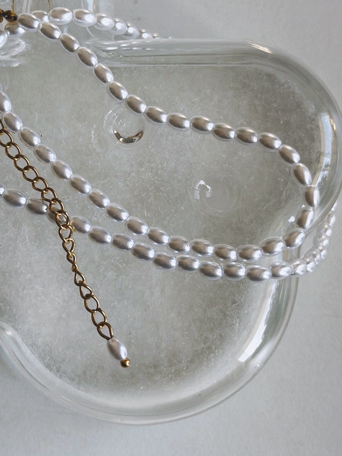淡水パールの柔らかな輝きが首元を彩るOUIのPerle Necklace N011です。チェーンの留め具の端にもパールが一粒あしらわれています。