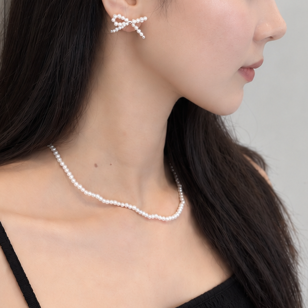 ビーズでできたOUI リボンピアス P027の白色を女性が着用している