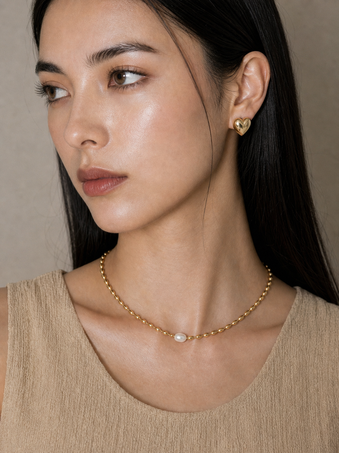 小ぶりなパールネックレスが首元にさりげない華やかさを添えるOUIの着用イメージです。